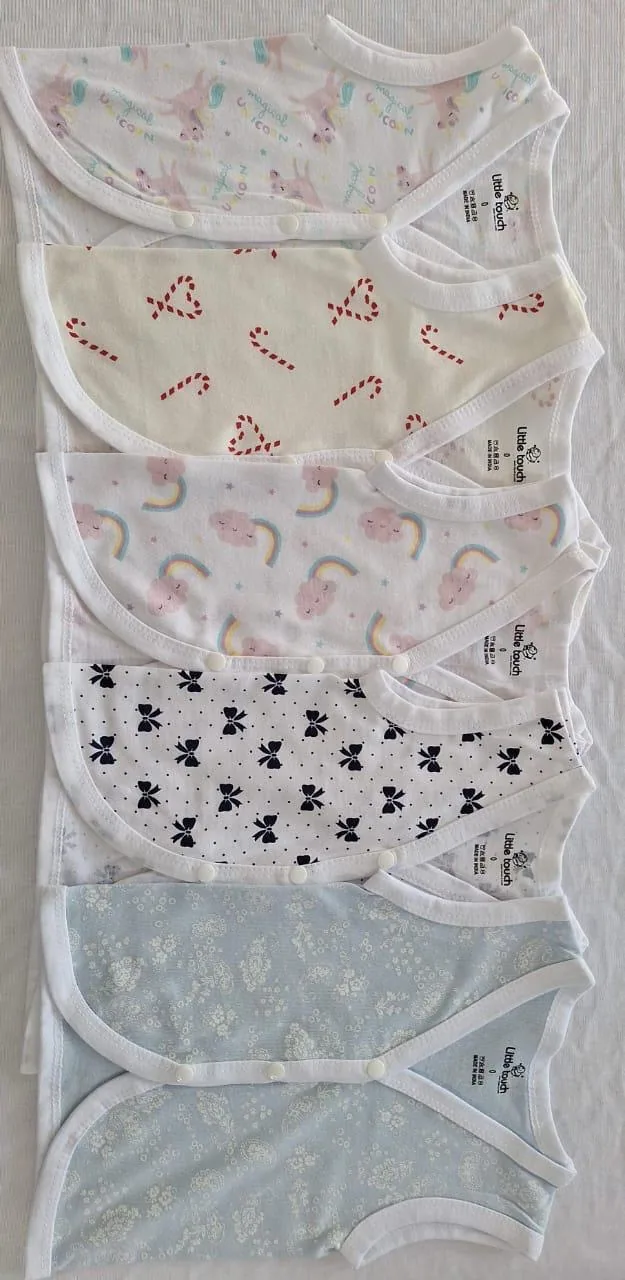 Sets of newborn clothing and cloth diapers laid out in rows ready for packing