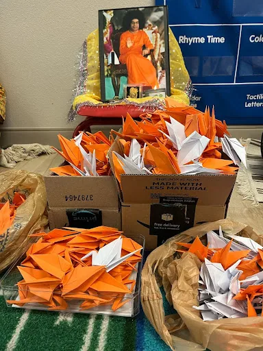 Folded orange paper cranes gathered in boxes